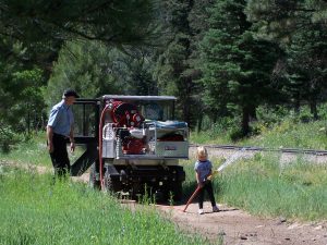 little girl using firehose off of fire truck vehicle