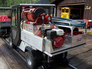 hyrailer vehicle with fire equipment in trunk on railroad tracks