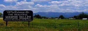 a sign on a grassy hill